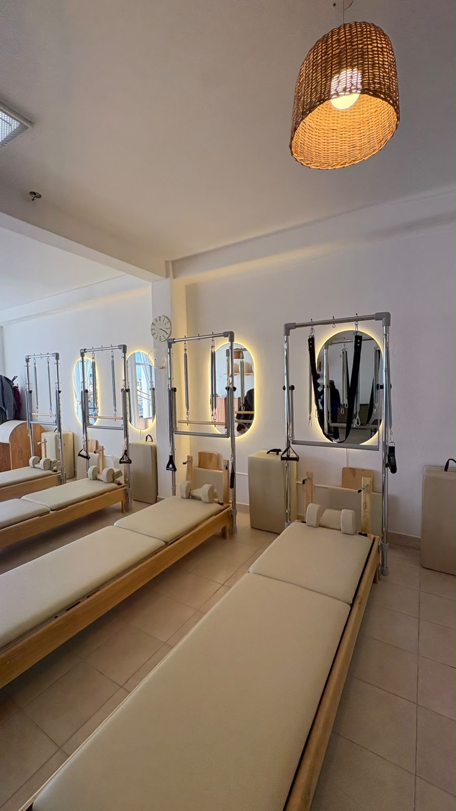 Camas Reformer y espejos iluminados dentro de Esencia Pilates